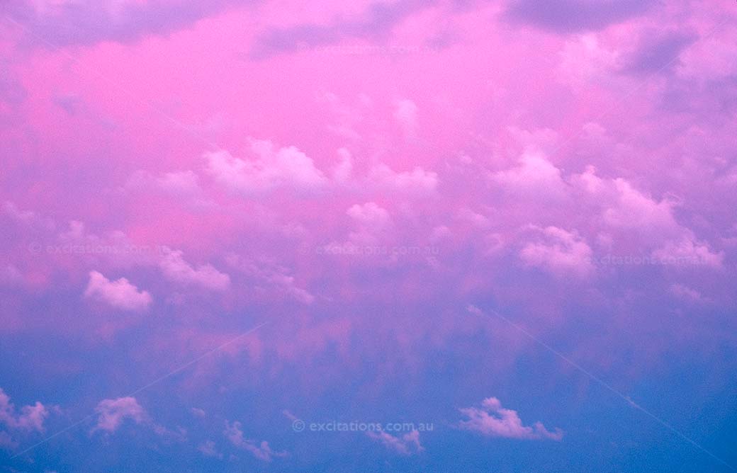 Vivid colours mostly pink and blue with white fluffy clouds
